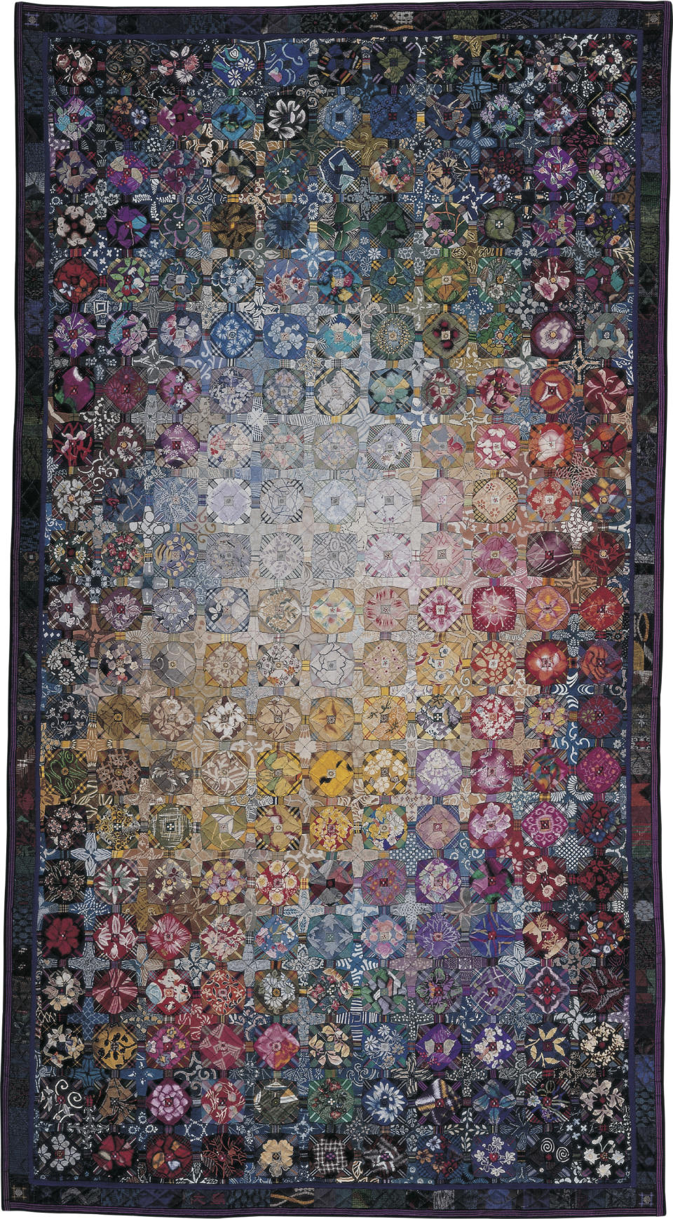 This image provided by the American Folk Art Museum shows the Yuen no Akari: Light From Far-away Space quilt made by Setsuko Obi in 2001. Standing a distance away from it gives you the impression of a glowing galaxy surrounded by brightly colored stars. But up close, you see that each block in the quilt is folded like origami, with hand-woven silks and fabrics from antique kimonos. (American Folk Art Museum via AP)