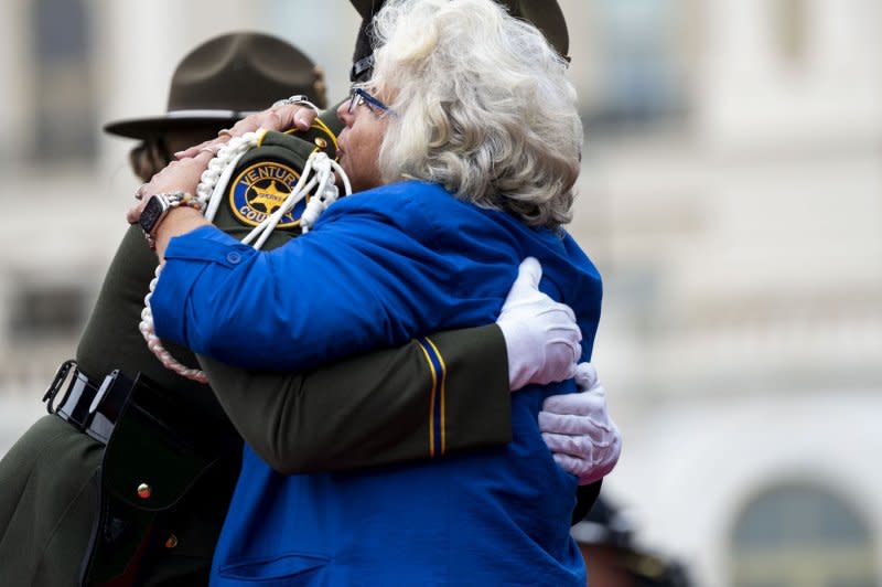 Connie Moyer (C), National President of the National Concerns of Police Survivors, hugs Andrew Hatlee, a deputy sheriff for the Ventura County, Calif. Sheriffs Department on Wednesday at the 43rd National Peace Officers' Memorial Service in Washington, DC. Photo by Bonnie Cash/UPI