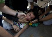<p>La gente ayuda a una mujer agobiada por el gas lacrimógeno lanzado por la Policía Nacional Bolivariana en Caracas, Venezuela, el sábado 8 de abril de 2017. (Foto AP / Ariana Cubillos)</p>