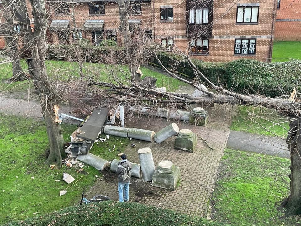 A tree blown over by the wind crashes into a portico, knocking it down in Tooting, southwest London (PA)