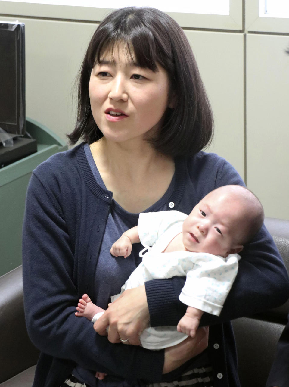 Ryusuke Sekino, a 5-month-old boy who was just 258 grams (9 ounces) when born, sits in the arms of his mother Toshiko Sekino at a hospital in Azumino, Nagano Prefecture, central Japan, Friday, April 19, 2019. The baby is among the tiniest baby boys to survive in the world. (Kyodo News via AP)