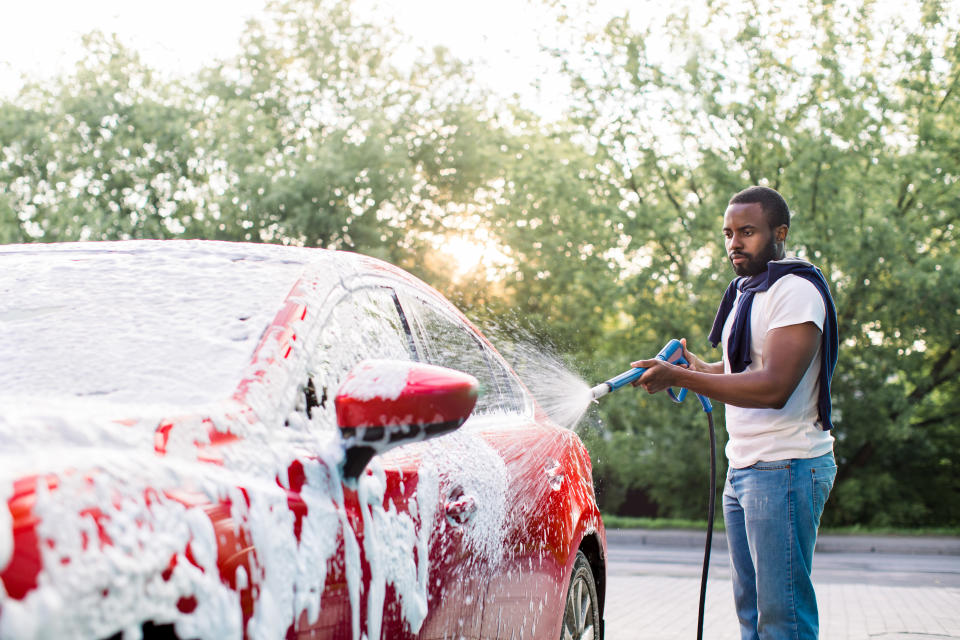 Man hosing down soapy car. Source: Getty Images