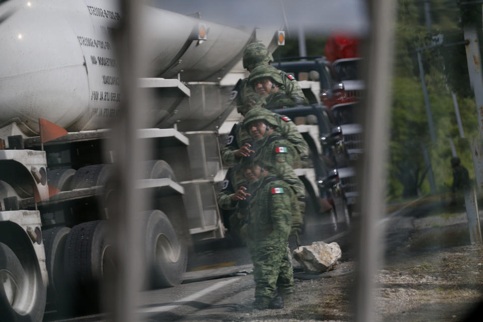 A soldier forming part of the National Guard is reflected in a slatted window while manning an immigration checkpoint north of Comitan, Chiapas state, Mexico, Sunday, June 16, 2019. Mexican President Andrés Manuel López Obrador said Saturday his country must help Central Americans fleeing poverty and violence, even as it increases security and revisions to deter migrants from passing through Mexico on route to the U.S. (AP Photo/Rebecca Blackwell)