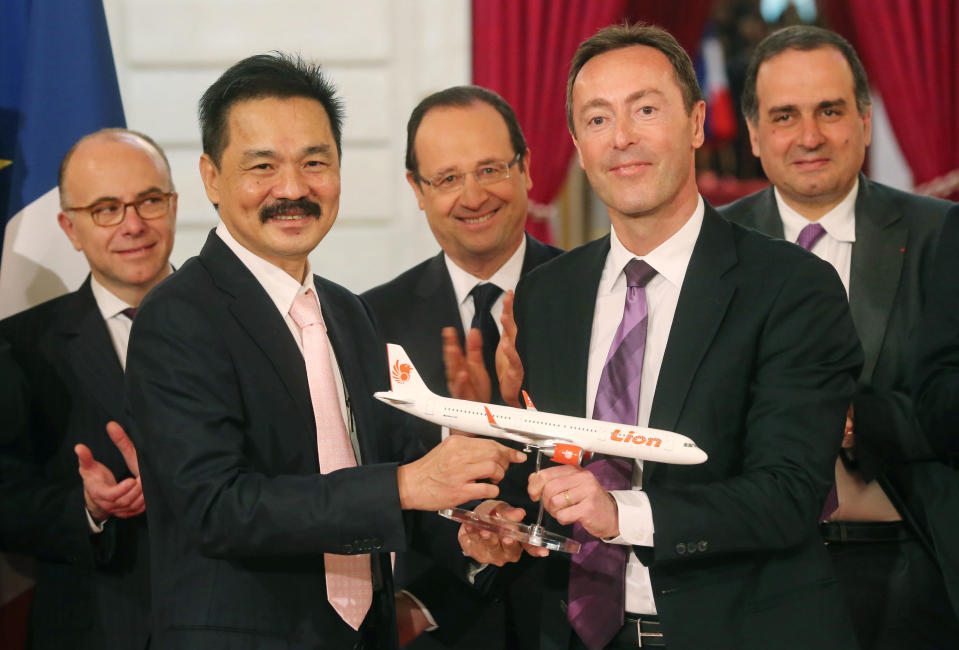 FILE - In this Monday, March 18, 2013 file photo, Lion Air President and chief executive Rusdi Kirana of Indonesia, second left, and Airbus President and chief executive Fabrice Bregier, second right, pose with an Airbus 320 model for the media while France's President Francois Hollande, center, applauds with others during a signing ceremony at the Elysee Palace in Paris when the Indonesian airline announced to buy 234 Airbus plane for 18.4 billion Euro ($24 billion). Indonesia's top discount carrier, which catapulted into the global aviation spotlight with record deals to buy Airbus and Boeing planes, is taking the battle for Asia’s budget-minded travelers to the backyard of the airline that helped pioneer low cost flights in the region. (AP Photo/Michel Euler, File)