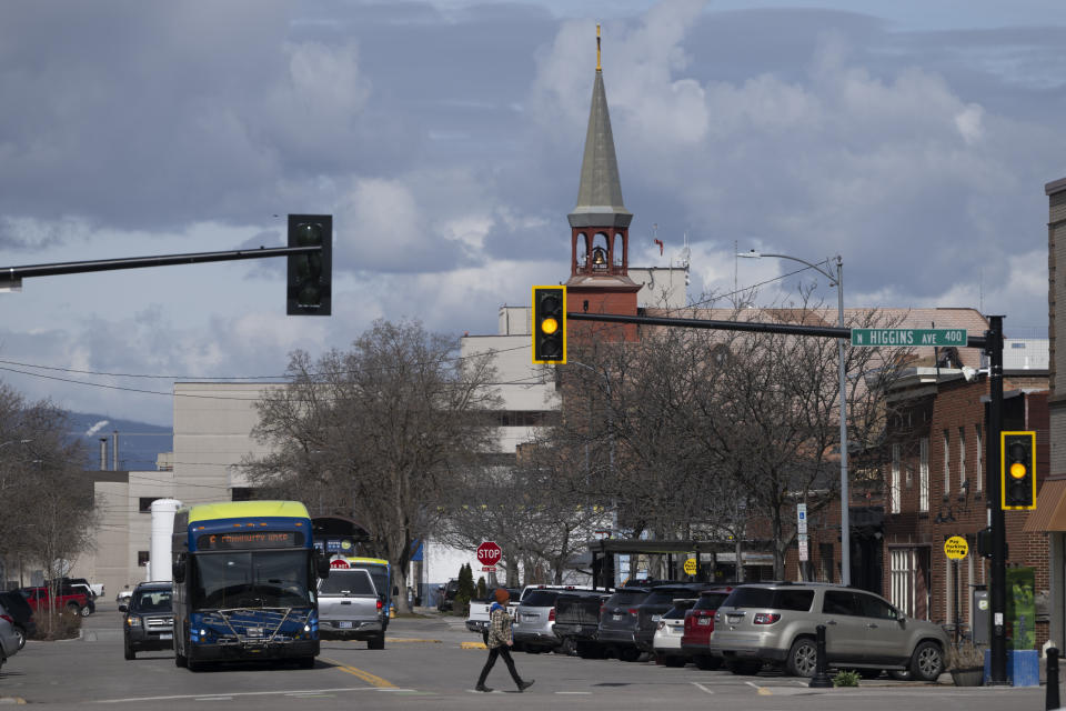 A pedestrian crosses a stree in Missoula, Mont., Tuesday, April 25, 2023. It was little surprise that Missoula, a college town where pride flags are a common sight, sent Zooey Zephyr to the state legislature. Zephyr, the first openly transgender legislator in Montana’s history, was barred last week from speaking on the floor of the legislature by the Republican majority. (AP Photo/Tommy Martino)