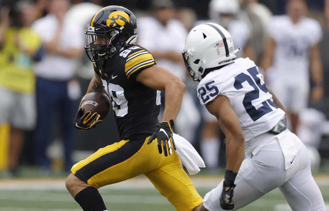 Iowa wide receiver Nico Ragaini (89) runs the ball as he is trailed by Penn State cornerback Daequan Hardy (25) during the first half of an NCAA college football game, Saturday, Oct. 9, 2021, in Iowa City, Iowa. (AP Photo/Matthew Putney)