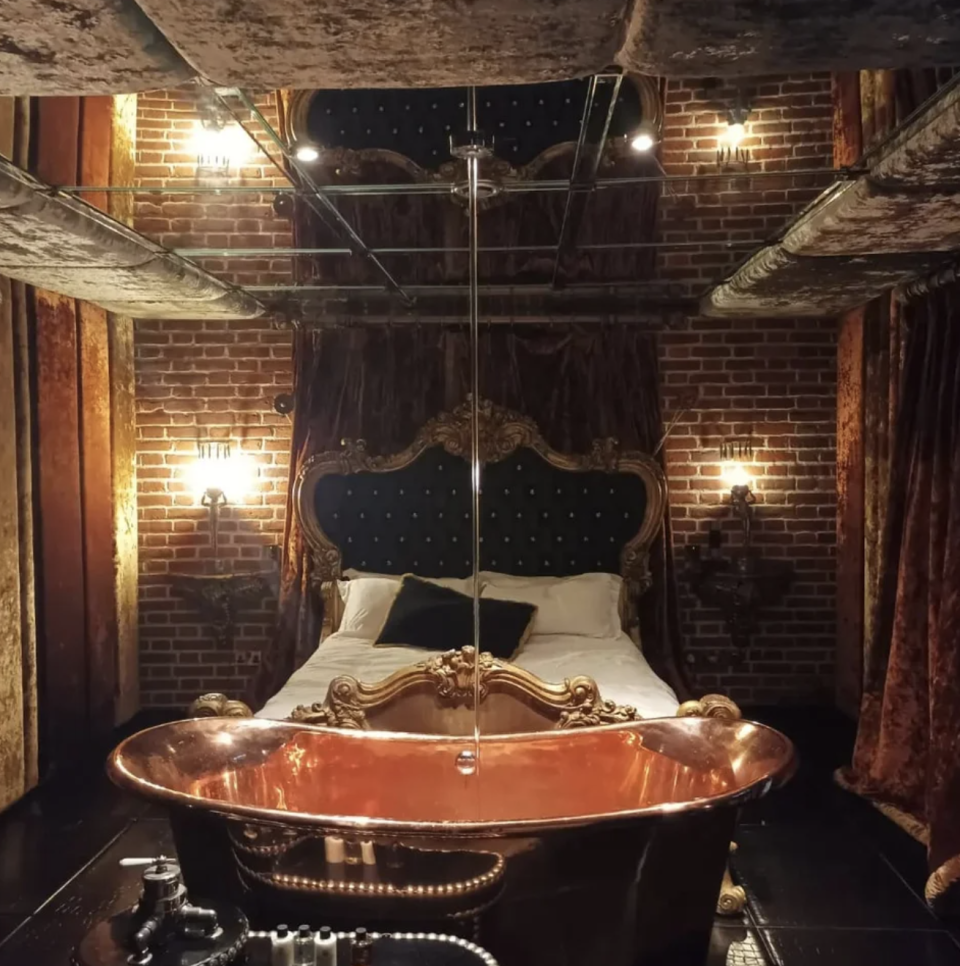 A bathtub at the foot of the bed