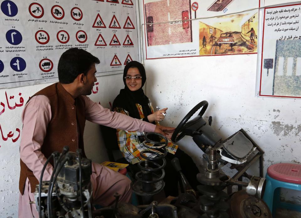 Tahmina talks to her instructor during a practical lesson at a driving school in Kabul