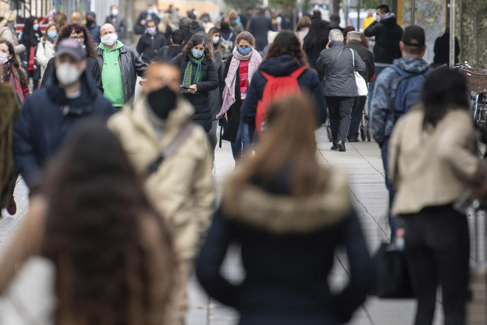 People wear mouth and nose protection as they walk through the city center in Stuttgart, Germany, Wednesday, Oct. 14, 2020. (Sebastian Gollnow/dpa via AP)