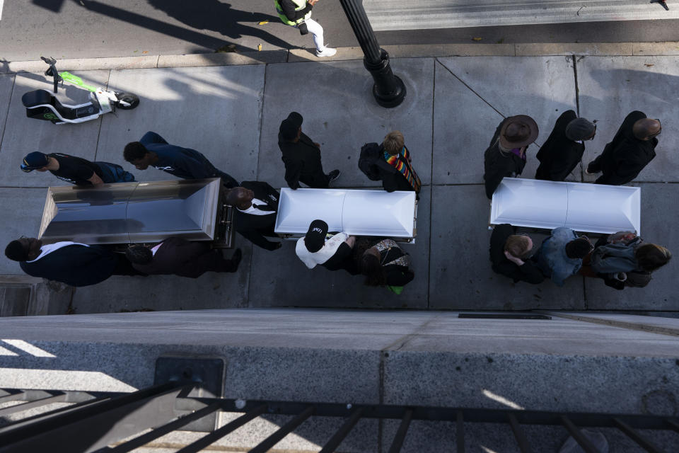 Demonstrators carry caskets to the entrance of the state Capitol to protest gun violence as part of the Tennessee Moral Monday rally in Nashville, Tenn., Monday, April 17, 2023. (AP Photo/George Walker IV)