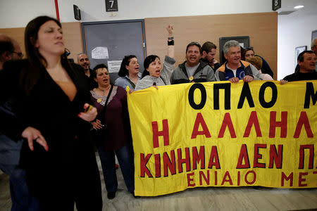 Protesters shout slogans as they block an entrance to prevent court officials from entering the courtroom and carry out an auction in Athens, Greece, March 29, 2017. Picture taken March 29, 2017. REUTERS/Alkis Konstantinidis