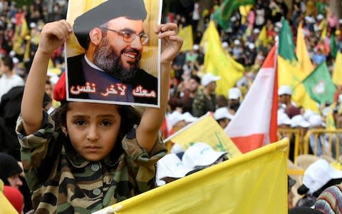 A child holds a picture of Hizbollah leader Sayyed Hassan Nasrallah during election rallies a few days before the general election in Baalbeck - Credit: Reuters