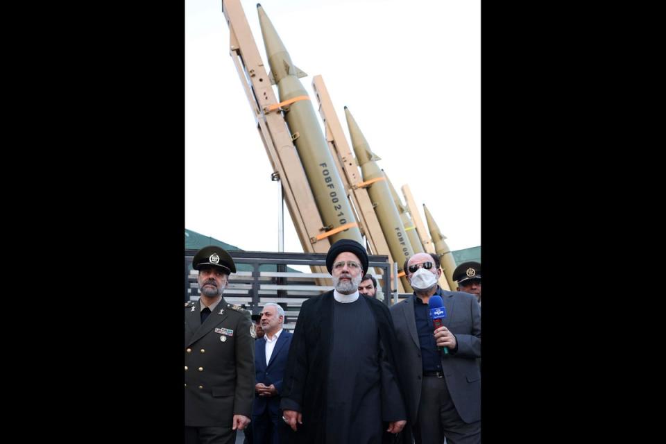In this photo released by the Iranian Presidency Office, President Ebrahim Raisi, center, attends a ceremony to deliver the domestically built missiles to the armed forces as his Defense Minister Mohammad Reza Gharaei Ashtiani, left, Iran, on Aug. 22, 2023.