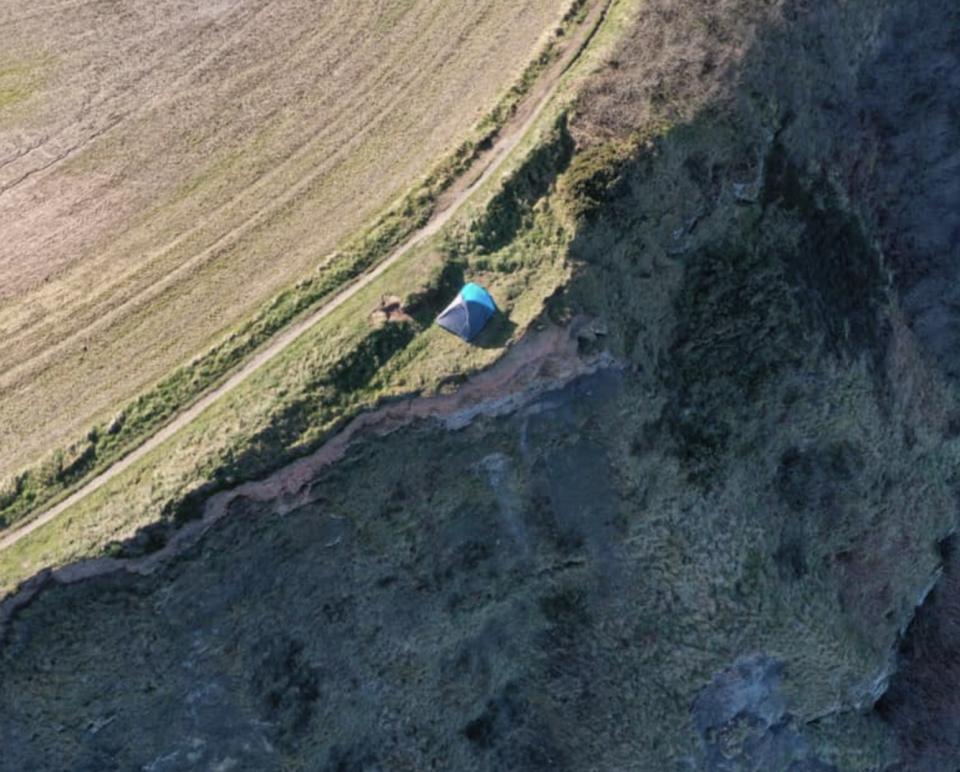 An aerial view of a tent pitched on the edge of a cliff in the United Kingdom during coronavirus lockdown.