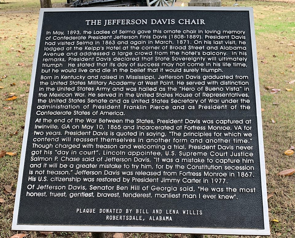 A plaque giving the history of the stone chair, dedicated to Jefferson Davis, in Live Oak Cemetery in Selma, Alabama.