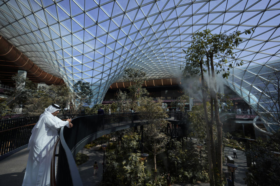 FILE - A Qatari man films new central concourse terminal expansion new airport opened to accommodate people arriving for the World Cup in Doha, Qatar, Thursday, Nov. 10, 2022. (AP Photo/Hassan Ammar, File)