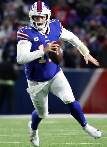 <p>Timothy T Ludwig/Getty</p> Josh Allen runs the ball for a first down against the New England Patriots during the first quarter in the AFC Wild Card playoff game on January 15, 2022 in Buffalo, New York.