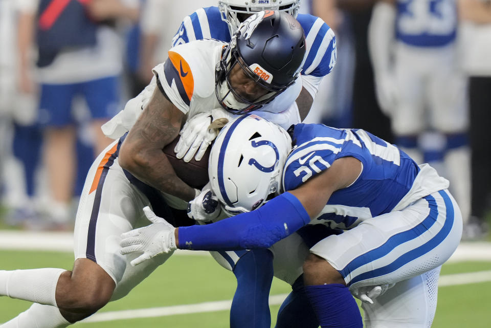 Denver Broncos wide receiver Tim Patrick (12) carries the ball against Indianapolis Colts safety Nick Cross (20) during the first quarter of a preseason NFL football game, Sunday, Aug. 11, 2024, in Westfield, Ind. (AP Photo/AJ Mast)