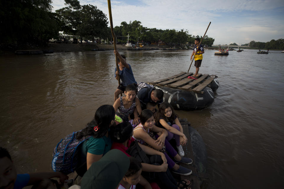 A group of more than a dozen Honduran migrants ride a raft across the Suchiate River after between Tecun Uman, Guatemala, left, and Ciudad Hidalgo, Mexico, Friday, June 14, 2019. Raftsmen and riverfront business operators said the flow of migrants through the crossing has slowed since the announcement a few days ago that Mexico's new National Guard would be deploying to the border. (AP Photo/Rebecca Blackwell)