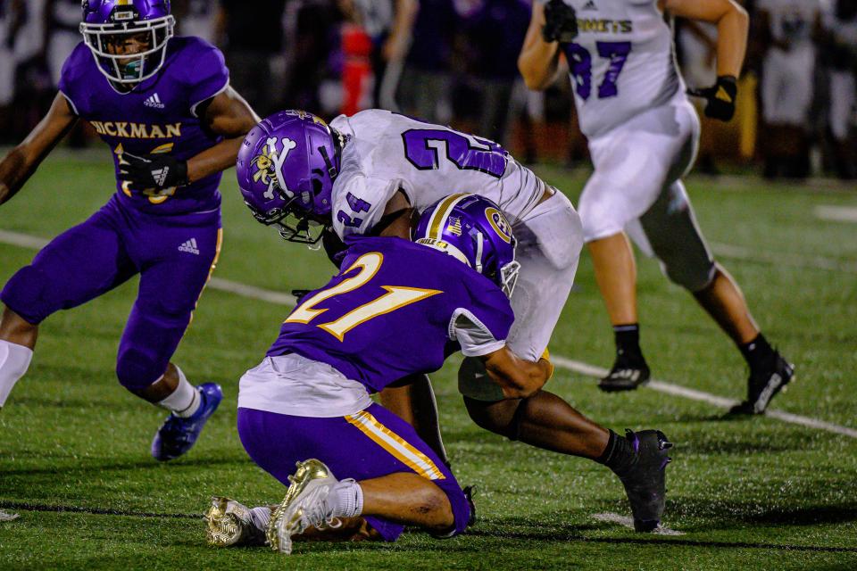 Hickman's Donivan Taylor (21) tackles North KC's Jermaine House Jr. (24) on Friday at Hickman High School.