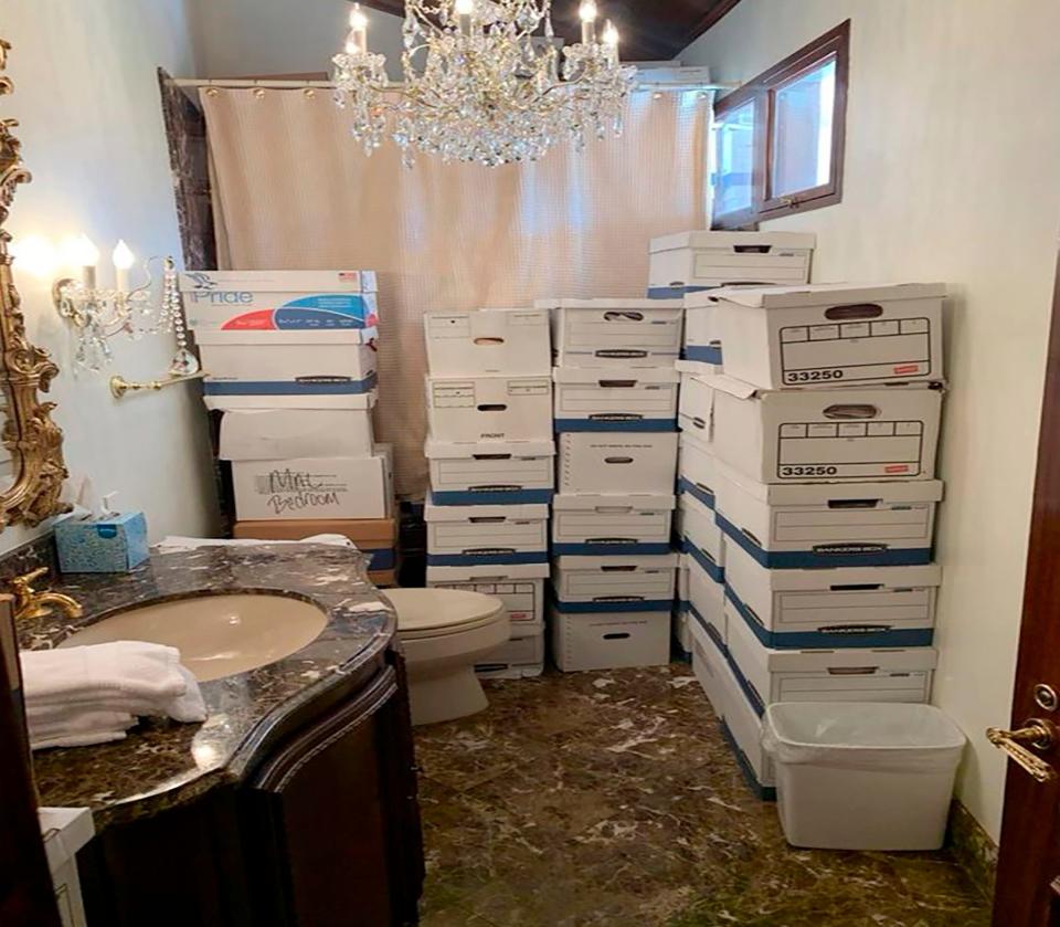A photo provided by the Justice Department, and included in the unsealed indictment of former President Donald Trump, shows document boxes in a bathroom and shower in the Lake Room at Mar-a-Lago.