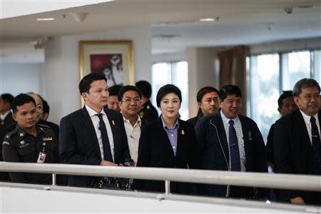 Thailand's Prime Minister Yingluck Shinawatra (C) leaves the Government Complex after a meeting with the Election Commission in Bangkok December 20, 2013. REUTERS/Athit Perawongmetha