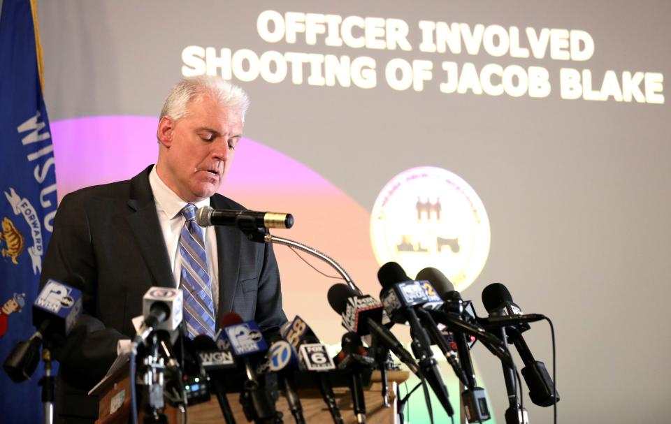 Kenosha County District Attorney Michael Graveley stands in front of microphones at a news conference