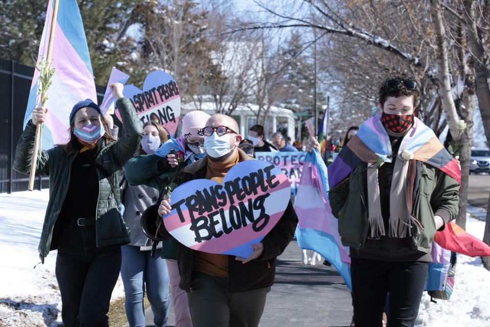 Advocates for transgender people march from the South Dakota governor's mansion to the Capitol in Pierre, S.D., on Thursday March 11, 2021, to protest a proposed ban on transgender girls and women from female sports leagues. (AP Photo/Stephen Groves)