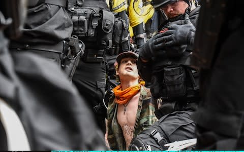 Demonstrator surrounded by police - Credit: Stephanie Keith/Getty Images