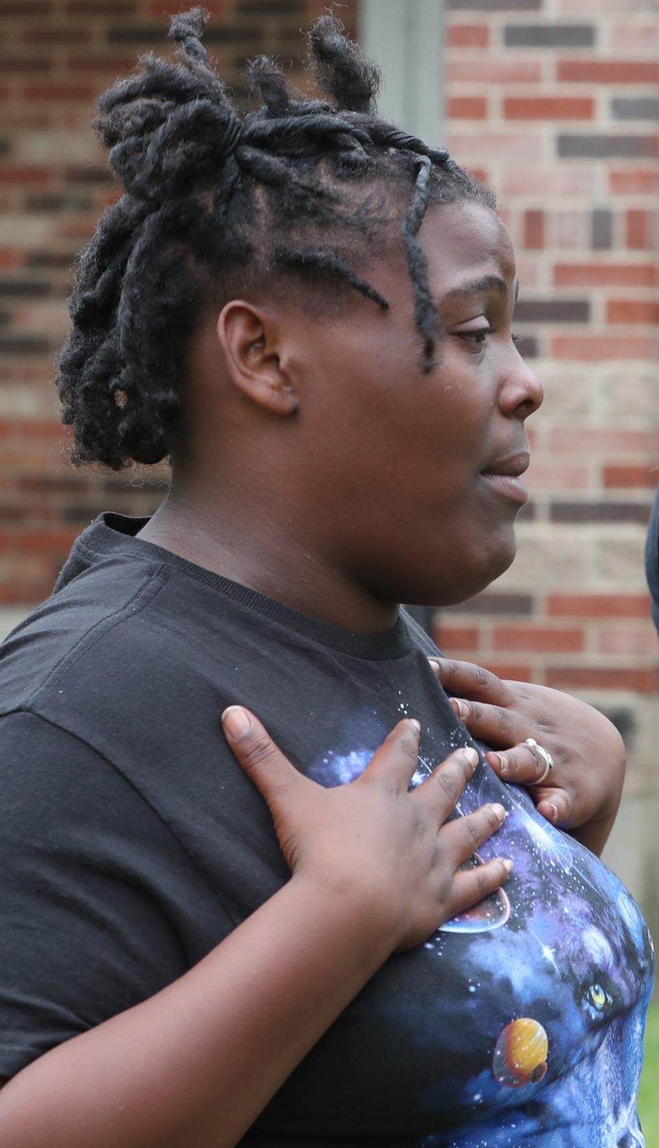 Joyous Payne, 21, pauses as she talks about being at a party and running for safety when shooting started early Sunday on Kelly Avenue in East Akron.