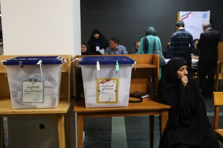 Electoral employees sits next to ballot boxes before closing vote for the presidential election in a polling station in Tehran, Iran, May 19, 2017. TIMA via REUTERS