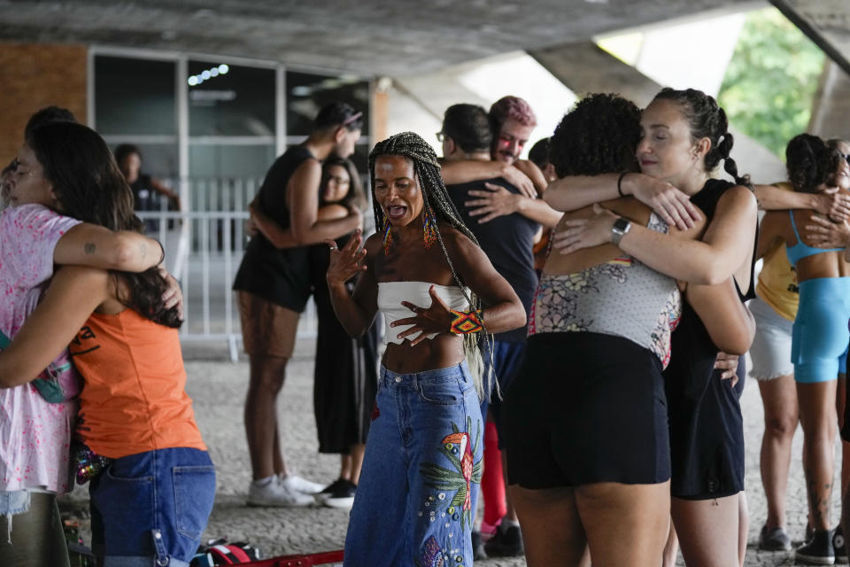 Instructor Raquel Potí, center, leads her stilt walking workshop that includes "interactive dynamic" exercises, akin to group therapy, at the Museum of Modern Art in Rio de Janeiro, Brazil, Saturday, Jan. 27, 2024. Potí believes that forcing her students to reckon with their vulnerabilities is key to their abilities to enchant the crowd. (AP Photo/Silvia Izquierdo)