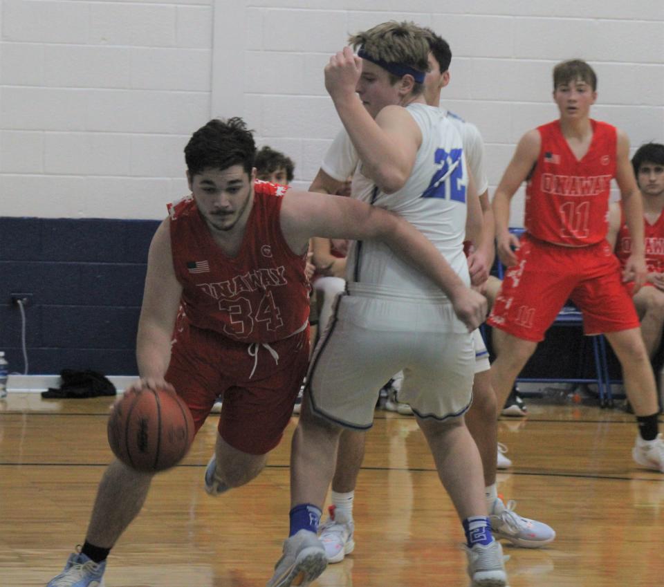 Onaway junior forward Justin Kramer-St. Germain (left) drives past Mackinaw City junior forward Lucas Bergstrom (22) during the third quarter on Thursday.