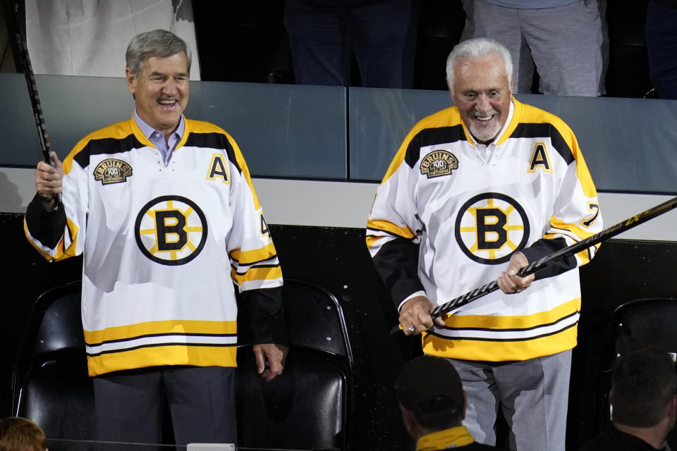 Boston Bruins greats Bobby Orr, left, and Phil Esposito laugh during a celebration of the 100th year of the team, prior to an NHL hockey game between the Bruins and Chicago Blackhawks, Wednesday, Oct. 11, 2023, in Boston. (AP Photo/Charles Krupa)