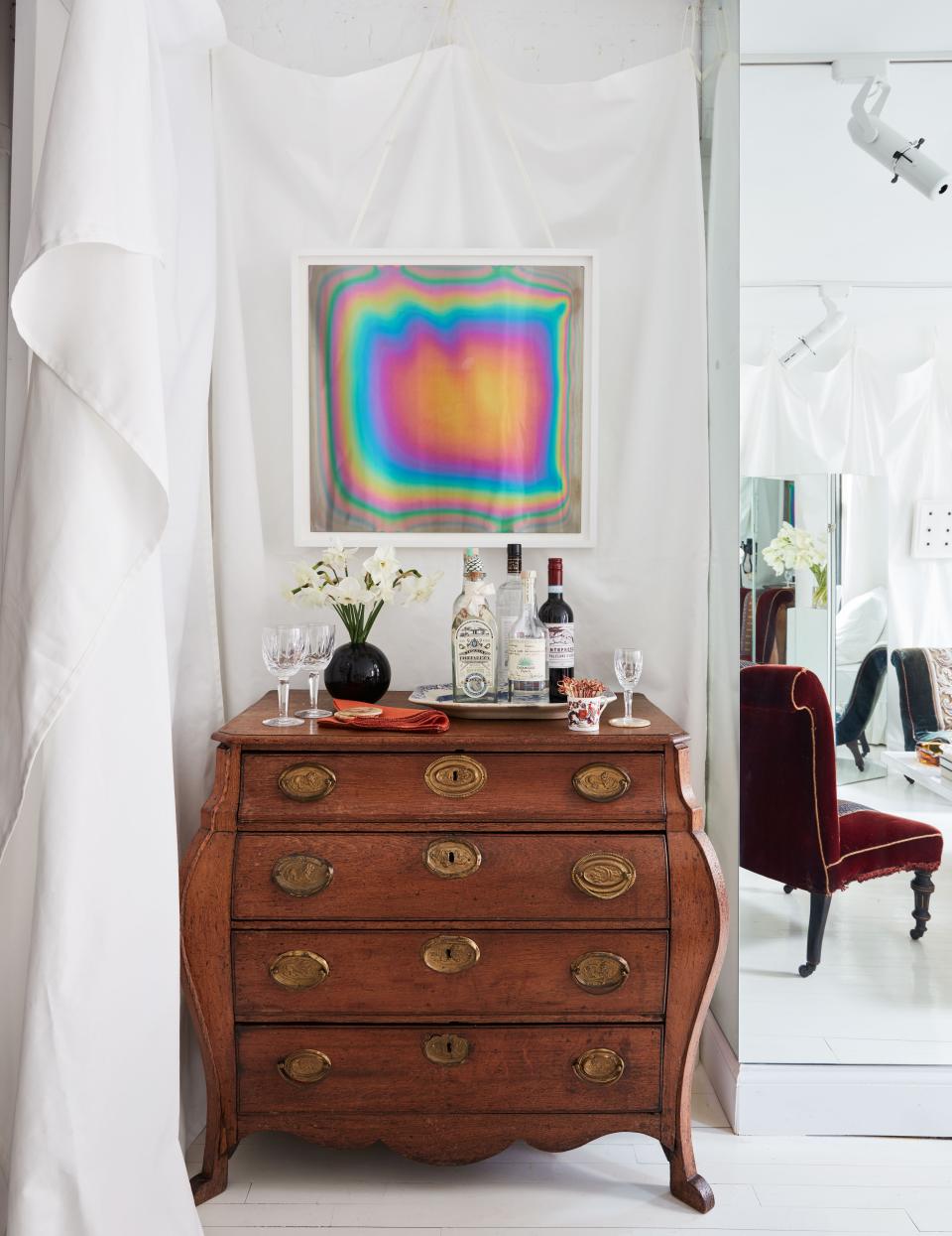 A framed artwork by Aleksandar Duravcevic hangs above the 18th-century chest.
