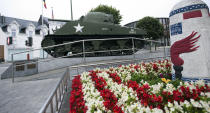 FILE - In this Aug. 29, 2015 file photo, a World War II tank and a marker are surrounded by flowers in the town center of Bastogne, Belgium. It was 75 years ago that Hitler launched his last desperate attack to turn the tide for Germany in World War II. At first, German forces drove so deep through the front line in Belgium and Luxembourg that the month-long fighting came to be known as The Battle of the Bulge. When the Germans asked one American commander to surrender, the famous reply came: “Nuts!" By Christmas, American troops had turned the tables on the Germans. Veterans are heading and on Monday, Dec. 16, 2019 when they will mix with royalty and dignitaries to mark perhaps the greatest battle in U.S. military history. (AP Photo/Virginia Mayo, File)