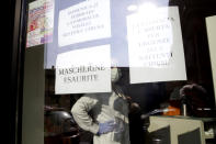 A note reading in Italian " Masks sold out " and "pharmacy is open for urgencies but shutters are closed", right, hang on the window of a pharmacy in Codogno, near Lodi, Northern Italy, Saturday, Feb. 22, 2020. A dozen northern Italian towns were on effective lockdown Saturday after the new virus linked to China claimed two fatalities in Italy and sickened an increasing number of people who had no direct links to the origin of the virus. The secondary contagions prompted local authorities in towns in Lombardy and Veneto to order schools, businesses and restaurants closed, and to cancel sporting events and Masses. (AP Photo/Luca Bruno)