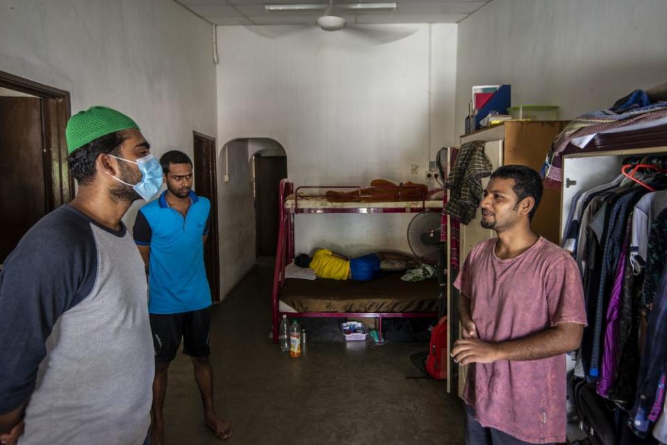 Shohel Mollah (left) talking to computer science graduate Ahmmad Ali who now works as a cleaner. — Picture by Shafwan Zaidon