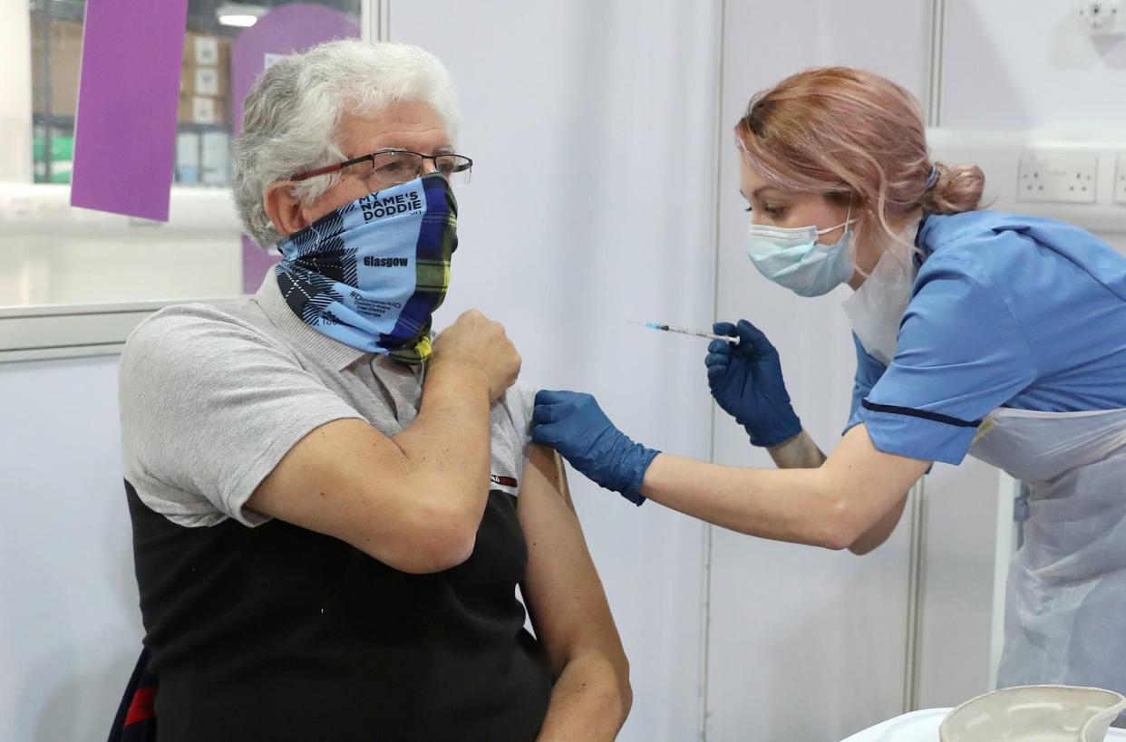 La soignante Nicole Clark administre un vaccin Covid-19 au résident de Glasgow John Loch, au NHS Louisa Jordan Hospital de Glasgow, le 10 février 2021. - Andrew Milligan - AFP