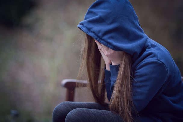 PHOTO: This undated stock photo shows a young woman sitting alone and covering her face with her hands. (STOCK PHOTO/Getty Images)