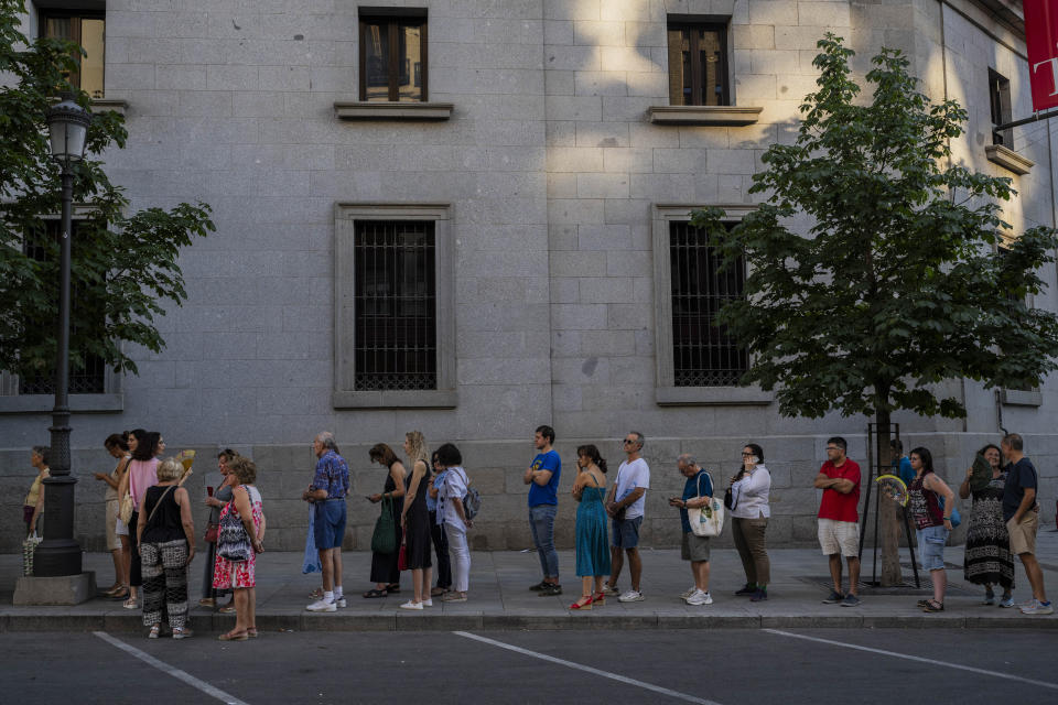 Un grupo de personas hace fila para acceder a los asientos antes de la representación de "Turandot", la ópera de Giacomo Puccini, en una pantalla gigante instalada el exterior del Teatro Real de Madrid, el 14 de julio de 2023. Desde hace ocho años, el Teatro Real ofrece la retransmisión gratuita de las óperas que se representan en su escenario a pueblos y ciudades de toda España. El objetivo es incentivar el interés por la ópera y librarla de su etiqueta de elitista. (AP Foto/Bernat Armangué)