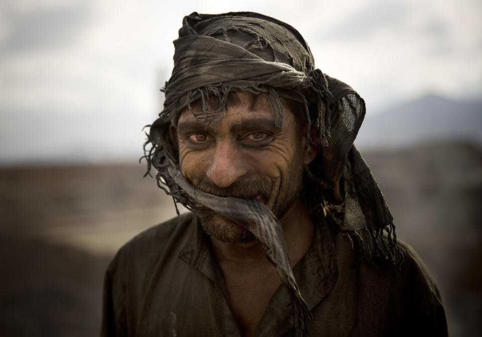 FILE - Day laborer Zekrullah, 23, takes a break from preparing brick kilns at a factory on the outskirts of Kabul, Afghanistan, Thursday, Nov 7, 2013. (AP Photo/Anja Niedringhaus, File)