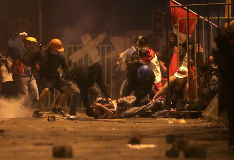 Foto del sábado de un manifestante siendo atendido por los paramédicos en medio de las protestas en Lima contra la situación política en Perú