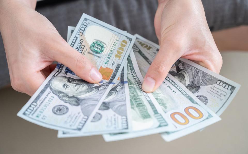 close up of someone hands holding and counting american dollar banknotes in her hand