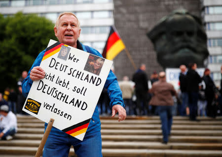 A demonstrator of the far-right "Pro Chemnitz" group holds a placard reading "Whoever does not love Germany, should leave Germany" in Chemnitz, Germany September 1, 2018. REUTERS/Hannibal Hanschke