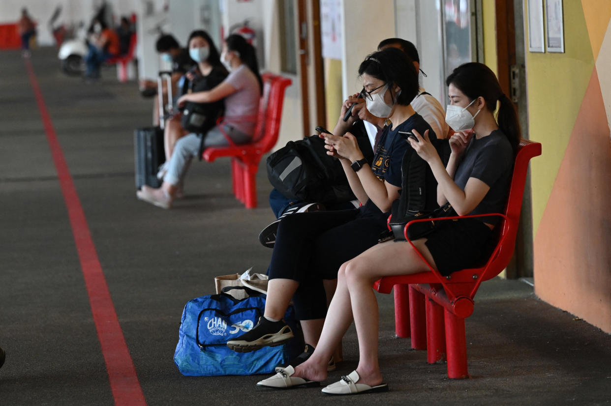 People wait for the bus in Singapore on November 29, 2021, under the vaccinated travel lane (VTL) for border-crossing passengers to Malaysia's southern state of Johor. (PHOTO: AFP / Roslan RAHMAN)