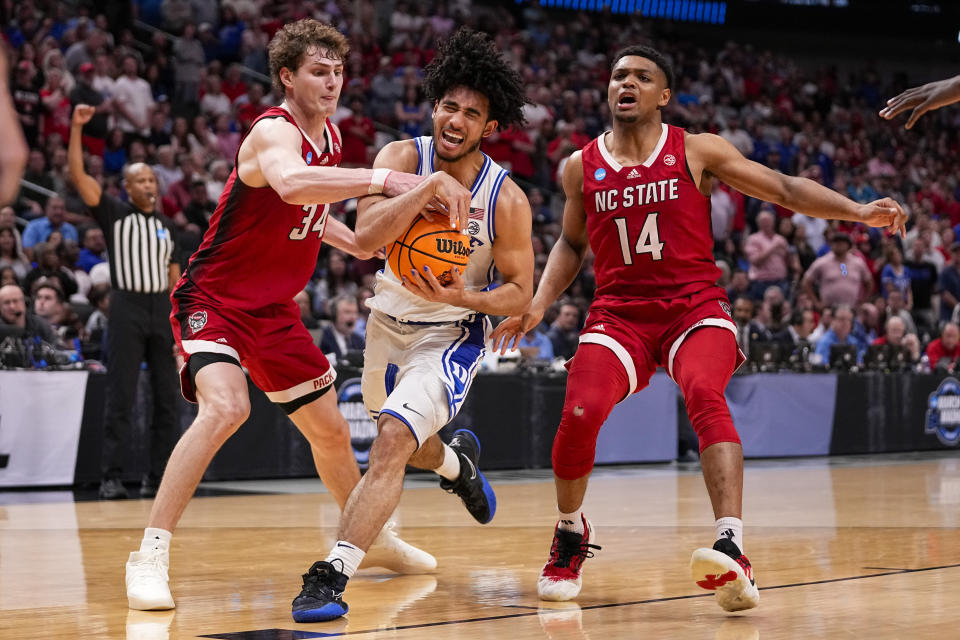 Duke's Jared McCain, center, drives against North Carolina State's Ben Middlebrooks (34) and Casey Morsell (14) during the second half of an Elite Eight college basketball game in the NCAA Tournament in Dallas, Sunday, March 31, 2024. (AP Photo/Tony Gutierrez)
