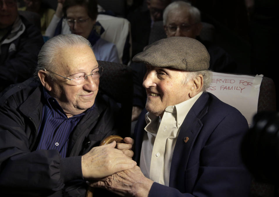 FILE - In this June 7, 2017, file photo, Holocaust survivors Israel Arbeiter, left, and Steve Ross greet one another at a theater before the premier of the film "Etched in Glass: The Legacy of Steve Ross," in West Newton, Mass. Ross, a Holocaust survivor who spent decades searching for the soldier who helped him at a concentration camp in 1945, died Monday, Feb. 24, 2020, Boston Mayor Marty Walsh said in a tweet. (AP Photo/Steven Senne, File)