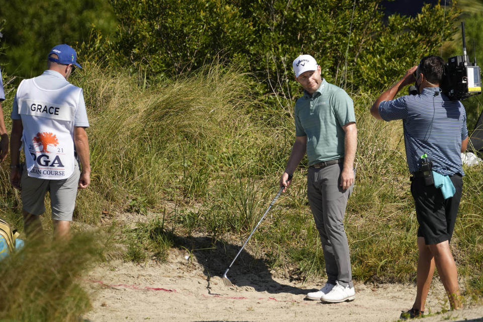 Branden Grace, of South Africa, prepares to take a drop due to an unplayable lie on the second hole during the first round of the PGA Championship golf tournament on the Ocean Course Thursday, May 20, 2021, in Kiawah Island, S.C. (AP Photo/David J. Phillip)