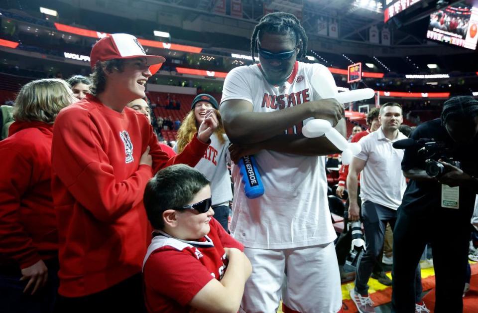 N.C. State’s D.J. Burns Jr. (30) poses with Caleb Firebaugh, 8, and his brother, Carter, 14, after the Wolfpack’s 94-66 victory over FSU at PNC Arena in Raleigh, N.C., Wednesday, Feb. 1, 2023.